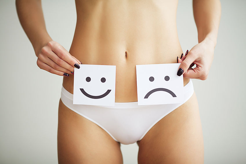 Woman Health Problem. Closeup Of Female With Fit Slim Body In Panties Holding White Card With Sad Smiley Face Near Her Stomach. Digestive Disorders, Period Pain, Health Issues Concept.